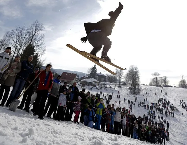 A participant jumps on vintage skis during a traditional historical ski race in the northern Bohemian town of Smrzovka February 21, 2015. (Photo by David W. Cerny/Reuters)