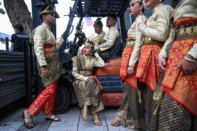 Volunteers wearing the Malaysian traditional dress called “Songket” wait before taking part in the 66th National Day celebrations in Malaysia's administrative capital Putrajaya, on August 31, 2023. The country commemorates the independence of the Federation of Malaya from British rule in 1957. (Photo by Mohd Rasfan/AFP Photo)