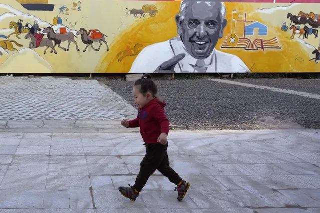 A child runs past a mural showing Pope Francis with depiction of nomadic daily life in Mongolian outside a church in Ulaanbaatar, Monday, August 28, 2023. When Pope Francis travels to Mongolia this week, he will in some ways be completing a mission begun by the 13th century Pope Innocent IV, who dispatched emissaries east to ascertain the intentions of the rapidly expanding Mongol Empire and beseech its leaders to halt the bloodshed and convert. (Photo by Ng Han Guan/AP Photo)