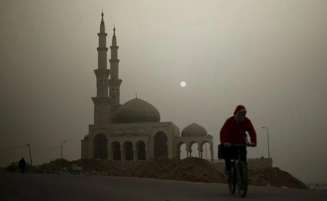 A Palestinian man rides his bicycle in front of a mosque on a stormy day in Gaza January 18, 2016. (Photo by Mohammed Salem/Reuters)