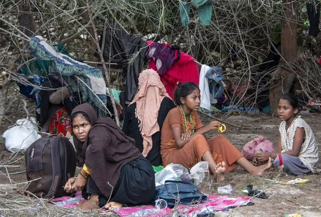 Ethnic Rohingya people rest on a beach after their boat was stranded on Idaman Island in East Aceh, Indonesia, Friday, June 4, 2021. Villagers in Indonesia's Aceh province discovered a stranded boat carrying dozens of Rohingya Muslims, including children, who had left a refugee camp in Bangladesh, officials said. (Photo by Zik Maulana/AP Photo)