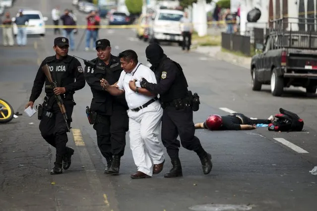 Policemen hold back the father (3rd L) of Jose Wilfredo Navidad after he reacted when recognising his dead son (on ground, R) at a crime scene in San Salvador, El Salvador January 26, 2016. Navidad and his friend Nestor Alexander Rivera were shot dead as they rode a motorcycle on their way to work. (Photo by Jose Cabezas/Reuters)