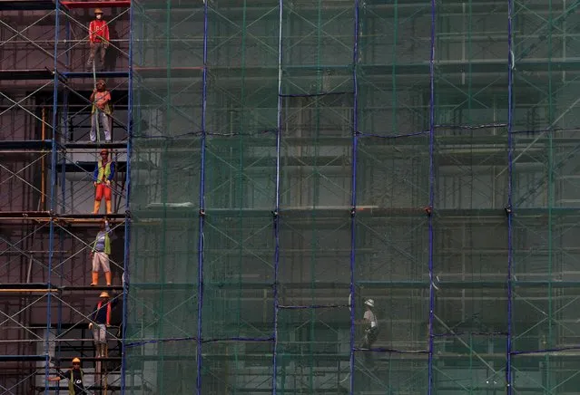 Workers stand in a scaffolding of a new building being constructed in Jakarta in this March 23, 2014 file photo. Indonesia is expected to report GDP numbers this week. (Photo by Reuters/Beawiharta)