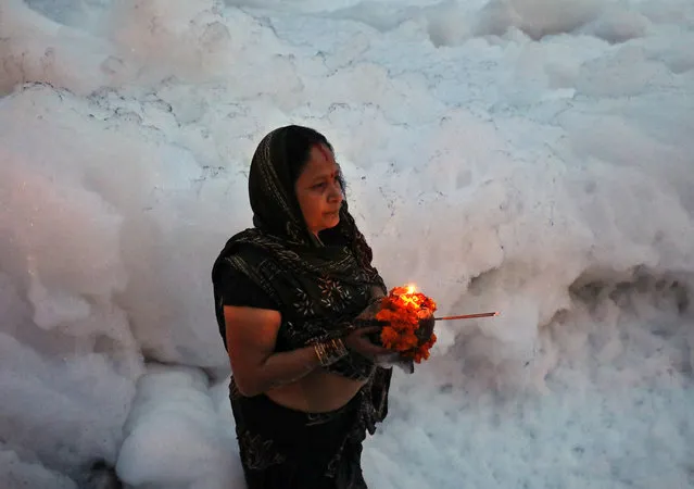 A Hindu woman worships the Sun god in the polluted waters of the river Yamuna during the Hindu religious festival of Chatth Puja in New Delhi, India, November 14, 2018. (Photo by Anushree Fadnavis/Reuters)