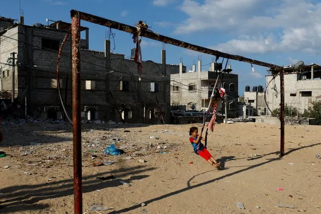 A child swings at the site of an Israeli strike, amid the ongoing conflict between Israel and Palestinian Islamist group Hamas, in Khan Younis in the southern Gaza Strip on October 19, 2023. (Photo by Ibraheem Abu Mustafa/Reuters)