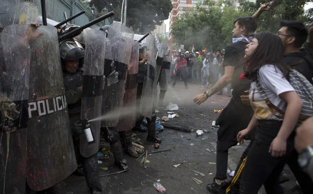 Police use pepper spray on opponents of Bolivia's President Evo Morales who are holding a national strike in La Paz, Bolivia, Thursday, December 6, 2018. Bolivian city's were semi-paralyzed on Thursday by a strike called by opposition groups a day after the country's top electoral court announced that it accepted Morales' candidacy for a fourth term in office, despite a constitutional ban and referendum against such a re-election. (Photo by Juan Karita/AP Photo)