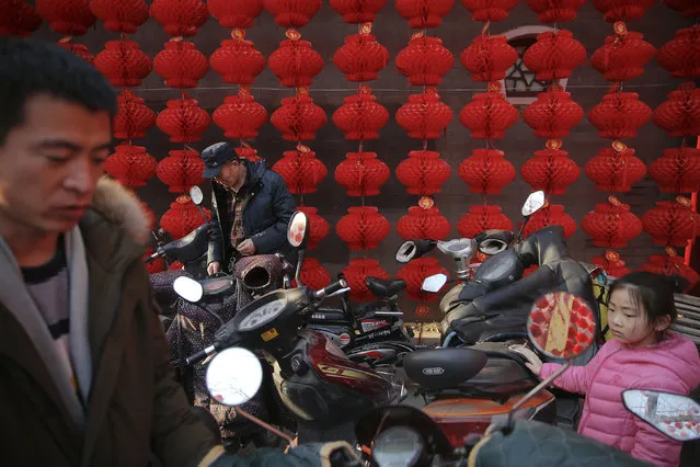 People pick up their motorcycles in front of decoration at the Longtan park as the Chinese Lunar New Year, which welcomes the Year of the Monkey, is celebrated in Beijing, China February 9, 2016. (Photo by Damir Sagolj/Reuters)