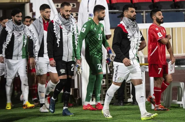 Palestinian players wearing traditional scarves enter the pitch ahead of the 2026 FIFA Soccer World Cup qualifier against Lebanon in Sharjah, United Arab Emirates, Thursday, November 16, 2023. (Photo by Martin Dokoupil/AP Photo)