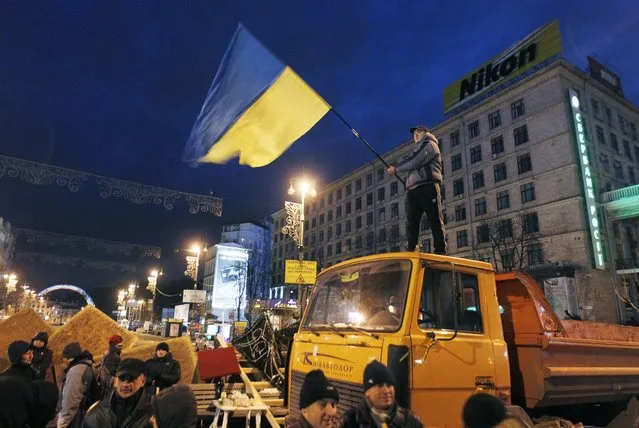 Protesters build up a barricade in a street around the city's Independent Square in Kiev, Ukraine, early 02 December 2013. (Photo by Sergey Dolzhenko/EPA)