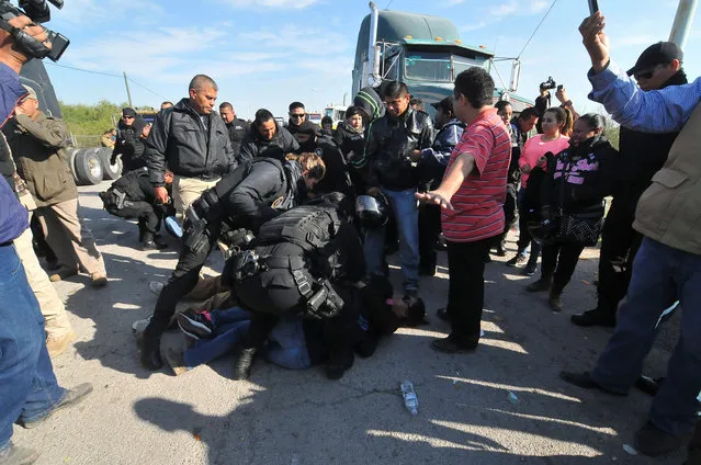 Policemen remove demonstrators blocking a road during a protest against the rising prices of gasoline enforced by the Mexican government, in Monclova, in Coahuila state, Mexico, January 5, 2017. (Photo by Fidencio Alonso/Reuters/Courtesy of Zocalo de Monclova)