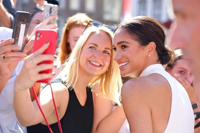 Meghan, Duchess of Sussex takes selfies with well-wishers outside the town hall during the Invictus Games Dusseldorf 2023 – One Year To Go events, on September 06, 2022 in Dusseldorf, Germany. The Invictus Games is an international multi-sport event first held in 2014, for wounded, injured and sick servicemen and women, both serving and veterans. The Games were founded by Prince Harry, Duke of Sussex who's inspiration came from his visit to the Warrior Games in the United States, where he witnessed the ability of sport to help both psychologically and physically. (Photo by Chris Jackson/Getty Images for Invictus Games Dusseldorf 2023)