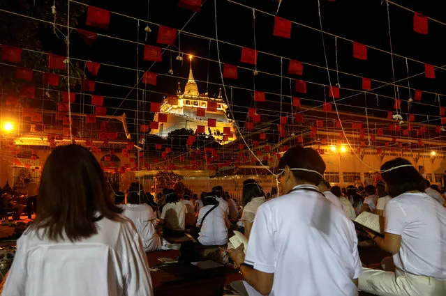 Thais pray to celebrate the New Year 2019 at the Golden Mountain temple or Wat Saket in Bangkok, Thailandon December 31, 2018. Strings attached are ceremonial threads given by Buddhist monks. (Photo by Athit Perawongmetha/Reuters)