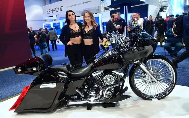 Promotion hostesses Justina (L) and Ty (R) pose beside a Harley Davidson motorcycle equipped with Cerwin Vega soundsystem at the 2017 Consumer Electronic Show (CES) in Las Vegas, Nevada on January 7, 2017. (Photo by Frederic J. Brown/AFP Photo)