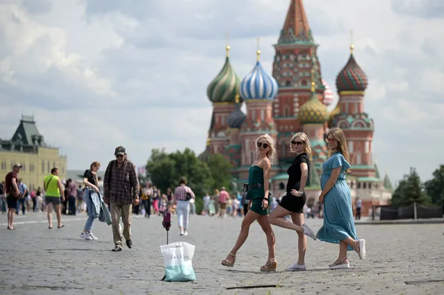 Young girls pose for a selfie picture on Red Square next to St. Basil's cathedral in Moscow, on July 21, 2021. (Photo by Natalia Kolesnikova/AFP Photo)