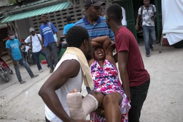 An injured woman is carried to the the Immaculée Conception hospital in Les Cayes, Haiti, Monday, August 16, 2021, two days after a 7.2-magnitude earthquake struck the southwestern part of the country. (Photo by Matias Delacroix/AP Photo)