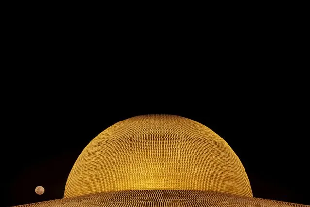 The full moon is seen over the Buddhist Wat Phra Dhammakaya temple during a ceremony on Makha Bucha Day in Pathum Thani province, north of Bangkok February 22, 2016. (Photo by Jorge Silva/Reuters)
