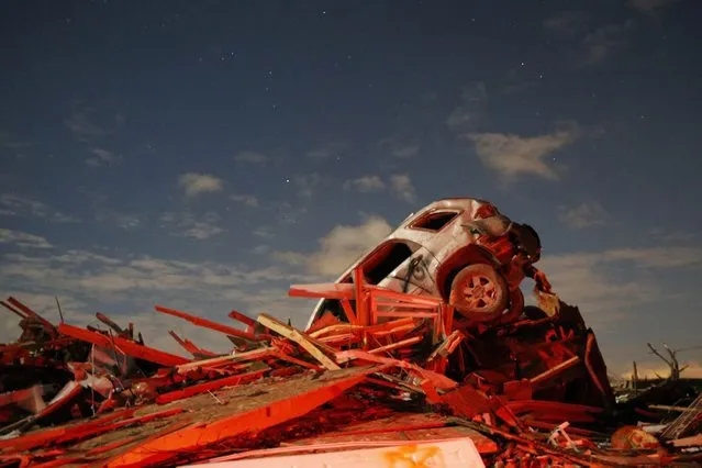 A vehicle sits on a pile of debris from the destruction caused by a tornado that touched down in Washington, Illinois. (Photo by Jim Young/Reuters)