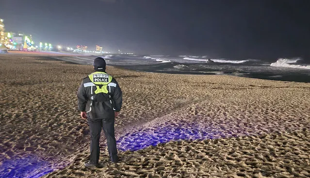 A member of Korea coast guard patrols to watch for possible changes in sea levels on a beach in Gangneung, South Korea, Monday, January 1, 2024. (Photo by You Hyung-jae/Yonhap via AP Photo)