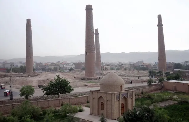 Afghans walk past the historical minarets in the center of Herat city, west of capital Kabul, Afghanistan, Tuesday, April 14, 2015. Only five out of more than dozen 15th century minarets still remain standing, due to a war and neglect. (Photo by Massoud Hossaini/AP Photo)