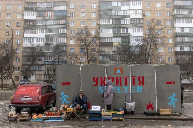People sell vegetables and other goods next to a bomb shelter at a market in Kramatorsk, Donetsk region, on January 19, 2024, amid the Russian invasion of Ukraine. (Photo by Roman Pilipey/AFP Photo)