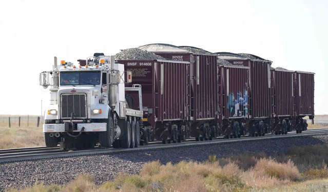 A rail-equipped truck hauling several railcars filled with gravel for track rebuilding and repair, Monday, September 27, 2021, arrives near Joplin, Mont., where an Amtrak train derailed Saturday, killing three people and injuring others. Officials have said they will try to repair the tracks quickly, as rail transport is crucial to the area's agricultural economy. (Photo by Ted S. Warren/AP Photo)