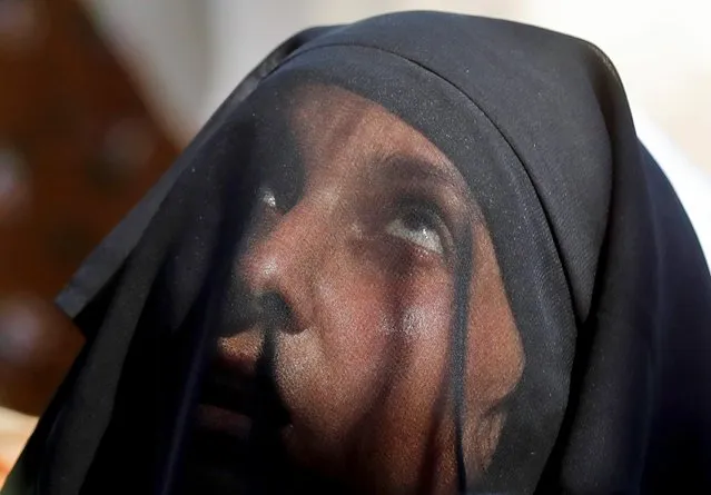 A Kashmiri Muslim woman looks up at a relic believed to be a hair from the beard of Prophet Mohammad, being displayed during the festival of Eid-e-Milad-ul-Nabi, the birth anniversary of the prophet, at Hazratbal shrine in Srinagar October 19, 2021. (Photo by Danish Ismail/Reuters)