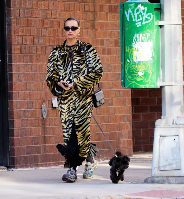 Irina Shayk and daughter Lea walk with their dog in New York City on February 6, 2024. The Russian supermodel wore a tige print trench coat, and colorful New Balance trainers. (Photo by The Image Direct)
