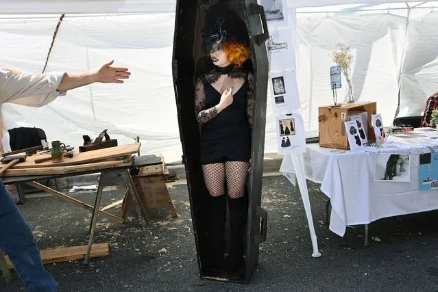 Rebecca Luo stands in a casket that was being used for people to take photographs during the International Edgar Allan Poe Festival and Awards on Sunday October 03, 2021 in Baltimore, MD. The writer died in Baltimore in 1849. His death is still clouded in mystery.(Photo by Matt McClain/The Washington Post)