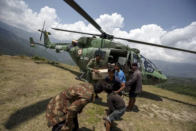 An indian military personnel and earthquake survivors unload relief supplies from an Indian Army helicopter near Sirdibas, Nepal May 2, 2015. (Photo by Athit Perawongmetha/Reuters)