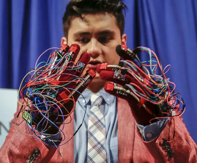 In this Tuesday, March 1, 2016, photo, maker Brendon Villalobos adjusts his gloves that translate live hand gestures into computer text input with the help of Intel's latest sensor-laden chip package, Curie, used to make Web-connected gizmos, during a live demo on set of “America's Greatest Makers”, a new reality TV challenge where teams of makers invent game-changing technology all for a chance at a $1 million prize at the Saticoy Studios in the Van Nuys neighborhood of Los Angeles. (Photo by Damian Dovarganes/AP Photo)