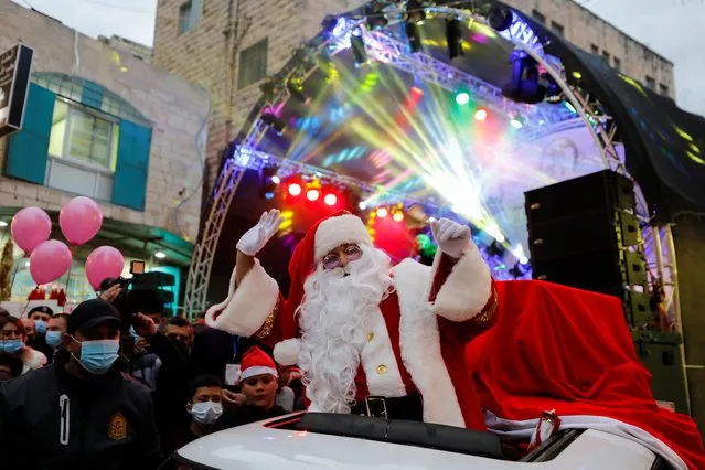 A Palestinian dressed as Santa gestures during a celebration in Bethlehem in the Israeli-occupied West Bank, December 2, 2021. (Photo by Mussa Qawasma/Reuters)