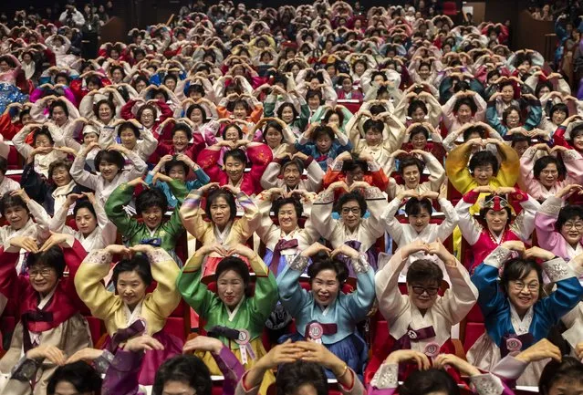 Graduates make heart gestures during their commencement ceremony at Ilsung Women's Middle and High School in Seoul, South Korea, 27 February 2024. The school with a two-year course is open to nontraditional students aged 40 and older who have not received regular education. (Photo by Yonhap/EPA)