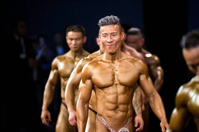 This photo taken on April 9, 2016 shows competitors posing during a bodybuilding competition in Hangzhou, eastern China's Zhejiang province. (Photo by AFP Photo/Stringer)