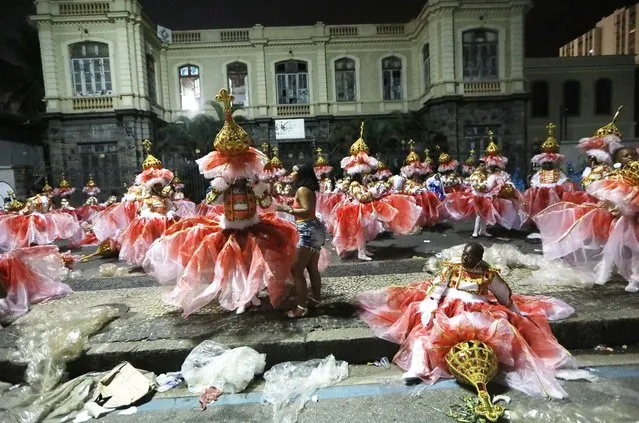 Revelers from the Portela samba school wait to perform outside the Sambodrome in the early morning hours during Carnival festivities on February 28, 2017 in Rio de Janeiro, Brazil. Up to 70 cities and towns in Brazil are believed to have canceled festivities for Carnival this year amidst a severe recession in the country. (Photo by Mario Tama/Getty Images)