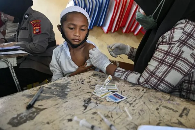 A student receives the Sinovac type of COVID-19 coronavirus vaccine at a primary school in Darul Imarah, Aceh province on January 14, 2022. (Photo by Chaideer Mahyuddin/AFP Photo)