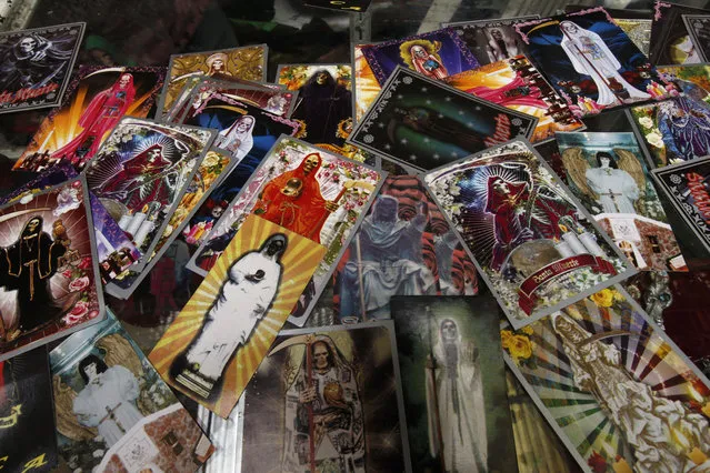 In this February 19, 2017 photo, images of the Death Saint or “Santa Muerte” hang for sale at Mercy Church on the edge of Mexico City's Tepito neighborhood. When Pope Francis visited Mexico in 2016 he expressed concern for those who “praise illusions and embrace their macabre symbols to commercialize death in exchange for money”. (Photo by Marco Ugarte/AP Photo)
