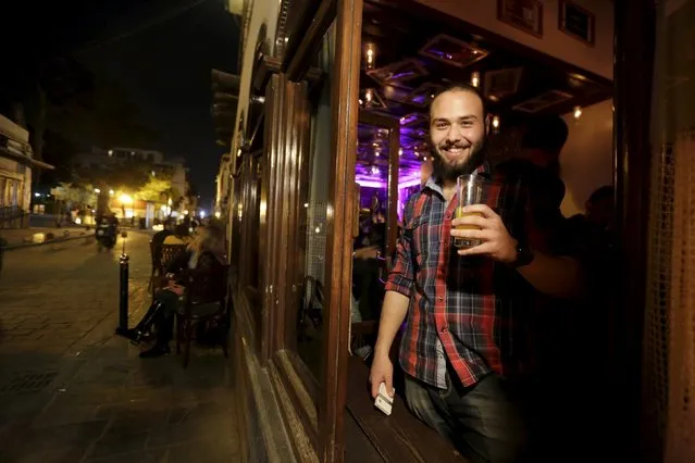 Kenan smiles as he carries a drink outside 80s Bar in Damascus, Syria, March 24, 2016. (Photo by Omar Sanadiki/Reuters)