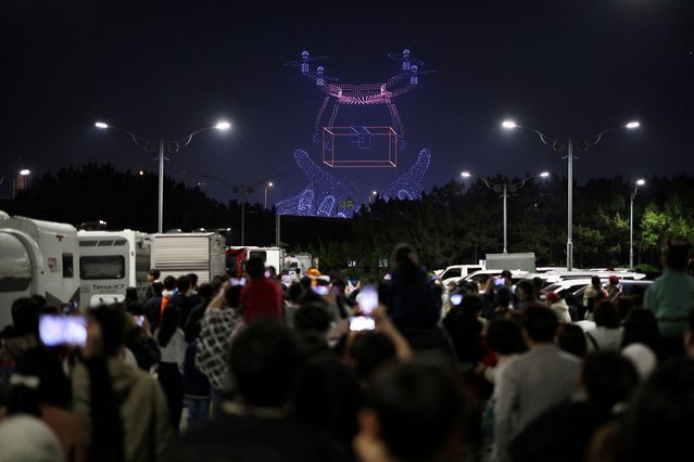 People watch drones' formation flying at the World Drone Light Show 2024, which is a part of the 2024 Korea Drone Expo, in Incheon, South Korea, on May 9, 2024. (Photo by Kim Hong-Ji/Reuters)