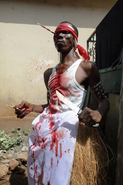 Amos Nicol, a Soko Bana (elder) with the Poro society holds a knife and a animal bone in his hand during a ritual performance in Freetown on November 21, 2018. In this ceremony the animal bone is used to pluck thru a member's eye with enough force to extract blood. This is a special performance that only Soko Bana members can perform. (Photo by Lynn Rossi/AFP Photo)