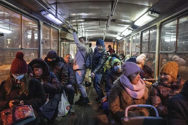 Passengers ride a bus in Kharkiv, Ukraine, Sunday, January 30, 2022. The situation in Kharkiv, just 40 kilometers (25 miles) from some of the tens of thousands of Russian troops massed at the border of Ukraine, feels particularly perilous. Ukraine's second-largest city is one of its industrial centers and includes two factories that restore old Soviet-era tanks or build new ones. It's also a city of fractures: between Ukrainian speakers and those who stick with the Russian that dominated until recently; between those who enthusiastically volunteer to resist a Russian offensive and those who just want to live their lives. Which side wins out in Kharkiv could well determine the fate of Ukraine. (Photo by Evgeniy Maloletka/AP Photo)
