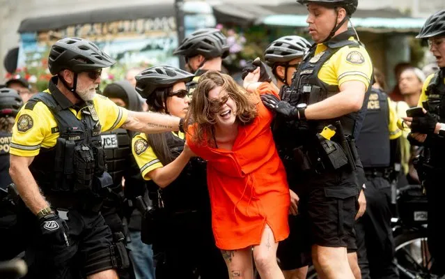 Police officers detain a protester against right-wing demonstrators following an “End Domestic Terrorism” rally in Portland, Ore., on Saturday, August 17, 2019. Although the main protest remained largely peaceful, some skirmishes erupted in the following hours and police detained multiple protesters. (Photo by Noah Berger/AP Photo)