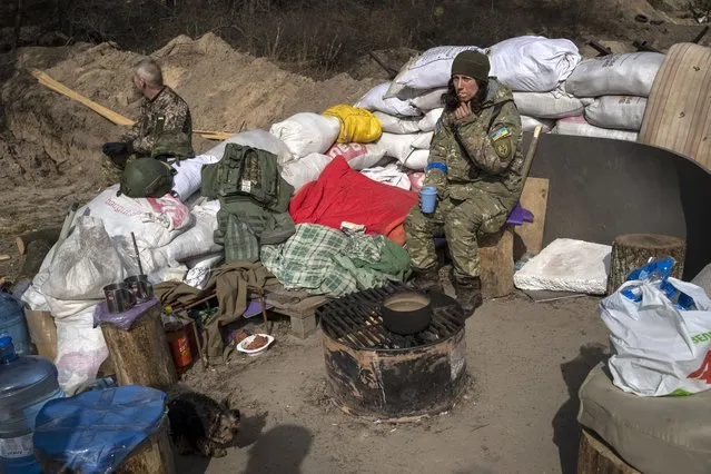 Ukrainian soldiers rest at a checkpoint in Brovary, on the outskirts of Kyiv, Ukraine, Saturday, March 26, 2022. (Photo by Rodrigo Abd/AP Photo)