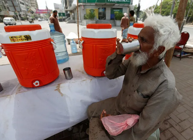 A man drinks a cup of water at a water distribution point set up on a street corner as preparations are made in case of another heatwave in Karachi, Pakistan May 15, 2016. (Photo by Akhtar Soomro/Reuters)