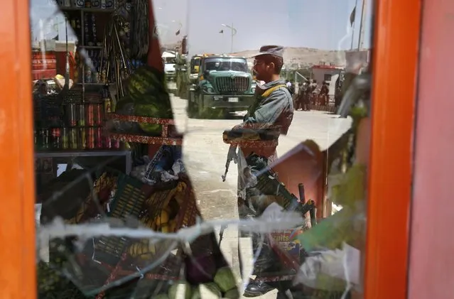 Afghan security officials are reflected in a broken window as they inspect the scene of a suicide bomb attack in Kabul, Afghanistan, 25 May 2016. At least 10 people were killed and four others wounded in a suicide bomb attack that targeted a bus carrying court employees on the outskirts of Kabul, according to media reports. (Photo by Jawad Jalali/EPA)