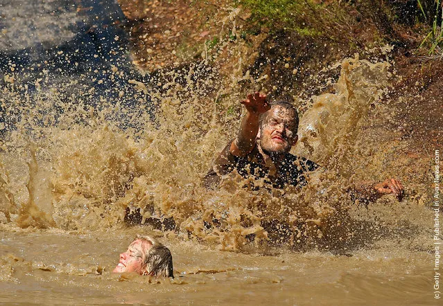 Competitors fall into muddy water as they compete in The Tough Bloke Challenge in Melbourne, Australia