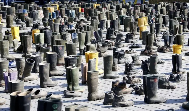 Pairs of used Wellington boots and shoes are displayed during a protest by German dairy farmers demanding a fair price structure for milk products, in front of the Brandenburg Gate in Berlin, Germany, May 30, 2016. (Photo by Fabrizio Bensch/Reuters)