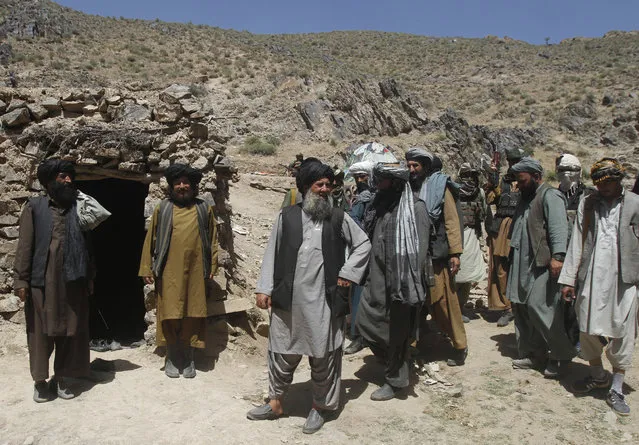 In this Friday, May 27, 2016 photo, Senior leader of a breakaway faction of the Taliban Mullah Abdul Manan Niazi, third left, arrives to give a speech to his fighters, in Shindand district of Herat province, Afghanistan. In the rugged terrain of the Taliban heartland in southern Afghanistan, the fight against Kabul has become a war for control of key stretches of main roads and highways as the insurgents use a new tactic to gain ground. (Photo by Allauddin Khan/AP Photos)
