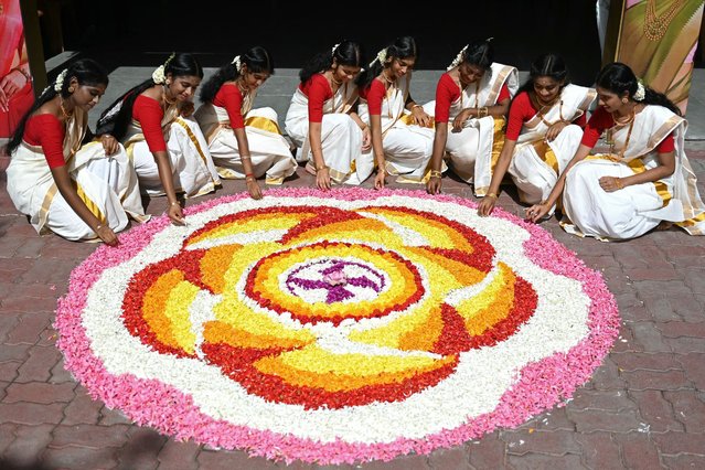 Students prepare a floral decorative design “Rangoli” during the celebrations to mark the annual harvest festival of “Onam” at a school, in Chennai on September 10, 2024. (Photo by R.Satish Babu/AFP Photo)