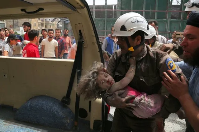 A civil defence member carries an injured girl after an airstrike in the rebel-controlled city of Idlib, Syria June 15, 2016. (Photo by Ammar Abdullah/Reuters)