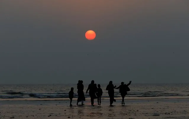 A family is silhouetted as they are visiting Clifton beach during the last sunset of 2019 in Karachi, Pakistan on December 31, 2019. (Photo by Akhtar Soomro/Reuters)